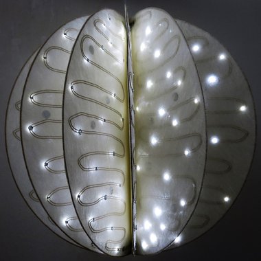 Textile LED-Lampe, die aus zwölf Segmenten mit jeweils 20 LEDs besteht. Durch eine gezielte Verschaltung der LEDs in Verbindung mit einer erhöhten Betriebsspan